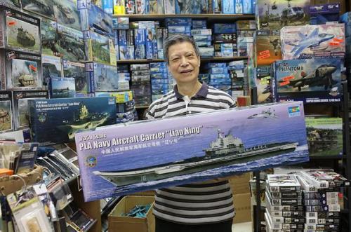 模型店老板萧锦春介绍辽宁舰模型。图片来源:香港《大公报》记者 蔡文豪 摄 模型店老板萧锦春介绍辽宁舰模型