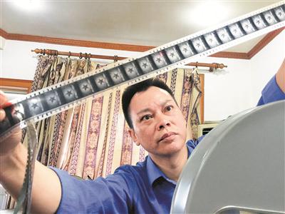 黄坚新在展示他收藏的胶片电影。通讯员 冼余汉 摄