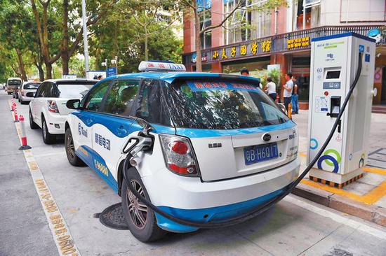 图为出租车正在使用宜停车泊位上设立的充电桩充电。