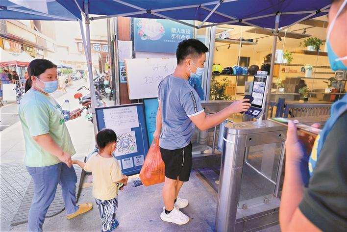 ▲近日，福田区莲花街道新狮村居民进入小区时，主动扫码亮码。