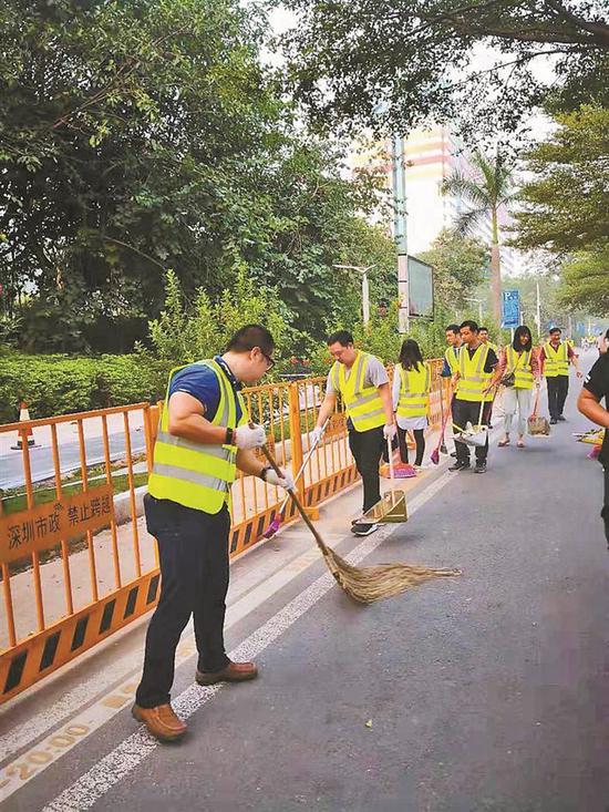 龙岗区志愿者开展爱心替岗活动，帮助环卫工人清扫路面。