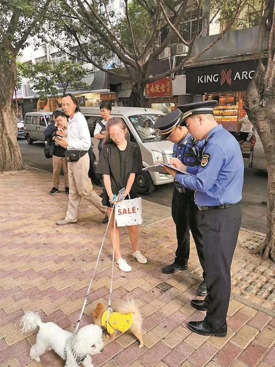 ▲执法人员纠正市民不文明养犬行为。 深圳晚报记者 冯明 通讯员 崔嵩 摄