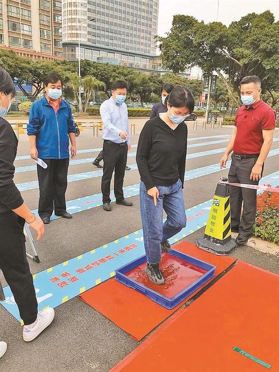 ▲学子进校门前须给鞋底消毒。 学校供图