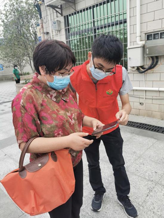 古嘉权（右）正在指导市民填写信息