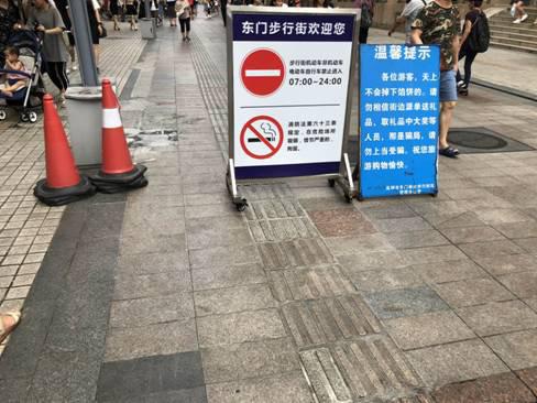 （ 东门步行街盲道被警示牌占据 ）