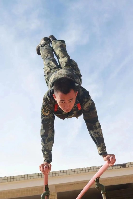 图为陈凯松在部队时进行双杠训练