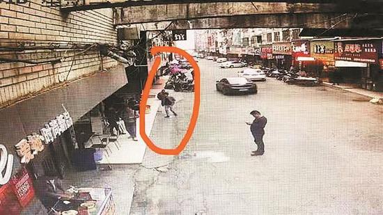 ▲犯罪嫌疑人蒋某龙（红圈中男子）与抓捕民警“擦肩而过”。