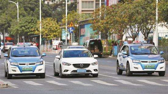 ▲“深圳出租”上线试运营。出租车司机可通过高德地图在线接单。图为路上行驶的电动出租车。 深圳晚报记者 张焱焱 摄