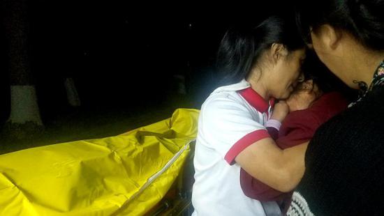 在向金华遗体捐献仪式上，深圳市红十字会和任达爱心护理院工作人员安慰向金华的母亲（中）