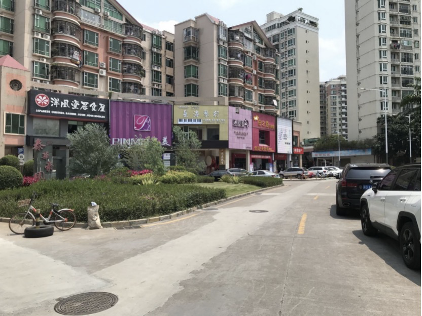 泰华豪园南门门口的富瑰路上,一排违停车辆大约占据了路面宽度的三分之一。