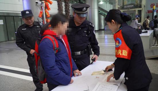 ▲民警和安检员在一名女性旅客上衣外套里查获一把菜刀。