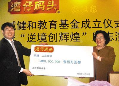 臧健和(右)向山东大学校长展涛(左)赠送捐款支票,设立臧健和教育基金。(图片来源:香港《文汇报》于永杰 摄)