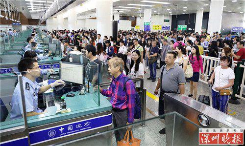 ▲边检民警开足通道快捷为经福田口岸出境旅客办理查验手续。黄俊生摄