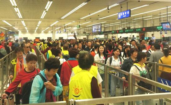 大批参加香港游旅行团的内地居民挤满皇岗口岸出境大厅自助查验区域