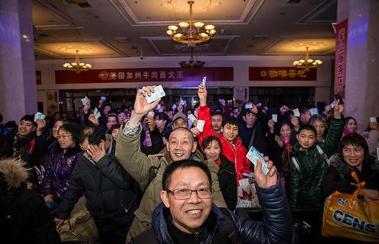 2018年2月1日凌晨,北京站,人们举着手中的车票。首趟增开普速列车北京站至重庆站3603次0:52发车。 东方IC 图