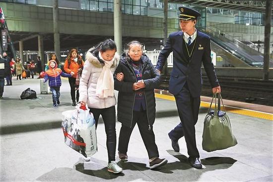 ▲深圳东站的工作人员协助旅客搭乘列车。