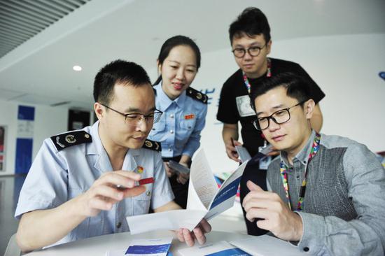 深圳税务部门主动送政策上门，图为税务干部在华星光电调研，讲解最新政策。
