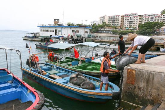 ▲开渔前，渔民正忙碌着搬运网具和储备食物。