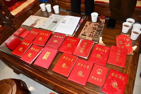 老兵陈武贤的荣誉证书和先进事迹报道材料差不多铺了满满一桌。