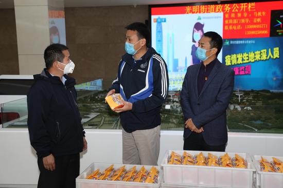 退伍军人蒋小林，吴太明（左一）向光明街道新冠肺炎疫情防控指挥部捐赠面包、牛奶等物资