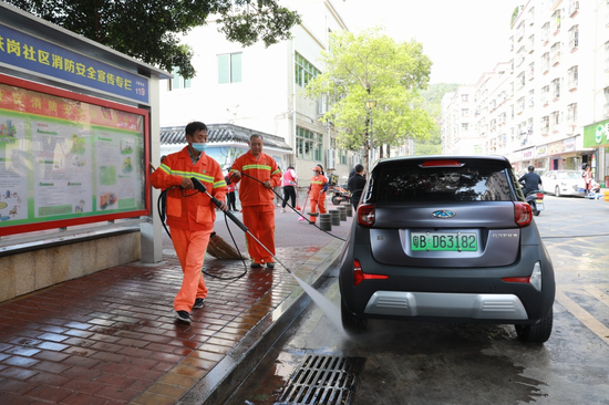 清洁工人使用高压水枪清洗路面