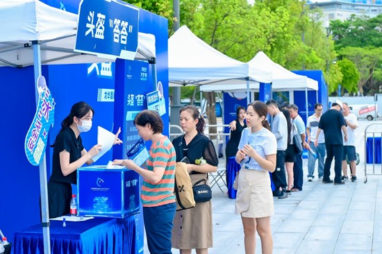 市民排队参加头盔“答答”互动游戏过程中了解龙华“智能头盔”