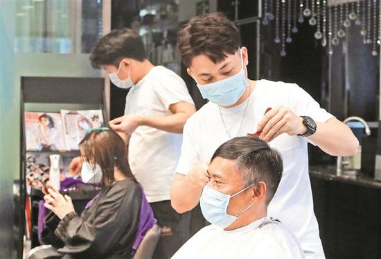 新闻路上只有2个理发店开门营业,理发师忙得停不下来。其他店仍未开业。 深圳特区报记者 李伟文 摄