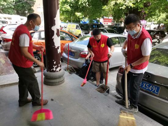 南湾街道党工委书记刘渊（右一）参加南岭村社区开展“全民清洁日”活动。