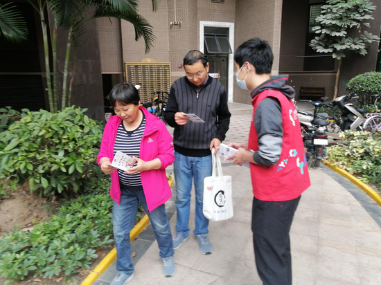 （庄边社区团委副书记向居民介绍社区志愿服务）
