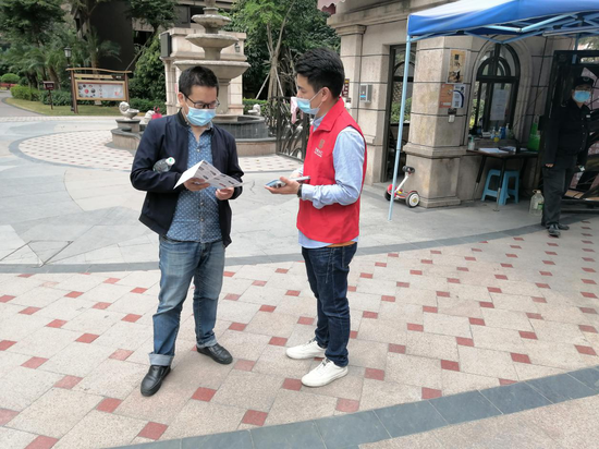  （庄边社区志愿者给居民发放志愿宣传折页）