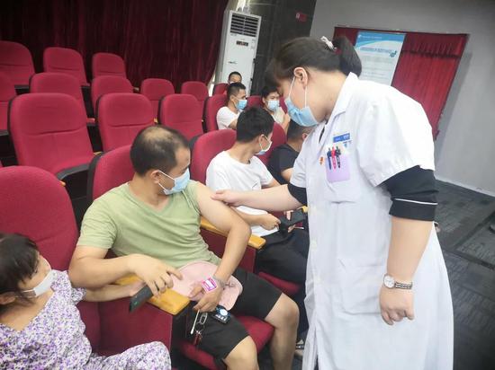 医护人员为留观区接种者做检查
