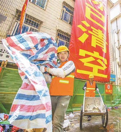 工作人员正在棚户区布心片区开展清楼行动。