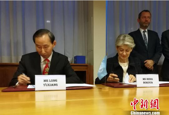 图为中国全国政协外事委员会委员、中国国际文化传播中心执行主席龙宇翔和联合国教科文组织总干事伊琳娜·博科娃签署协议。 刘思敏 摄