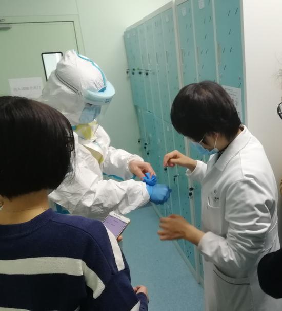 彭净在指导医务人员穿戴防护装备。
