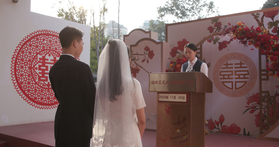 在福田区婚姻登记处中式颁证厅,颁证员向新人颁发结婚登记证书