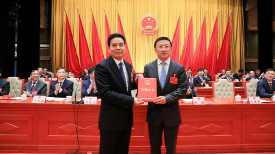 周益川（左）为范德繁（右）颁发当选证书