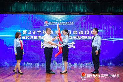 高潮迭起。深圳市税务局党委委员、副局长李伟为落实减税降费政策党员先锋队授旗。