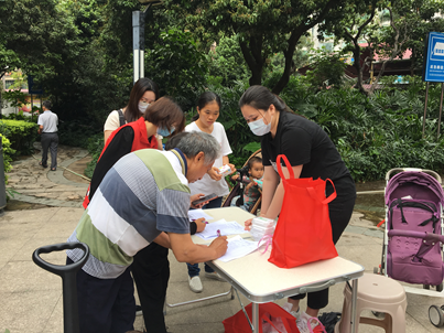 社工在引导居民签到和拿剪发序号