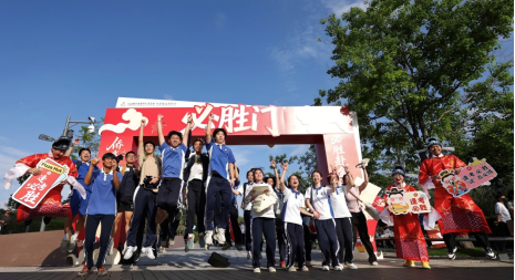 老师和同学们一起在必胜门前跳跃祝同学们高考必胜