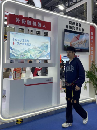 　市民在深圳工行展位现场体验外骨骼机器人。