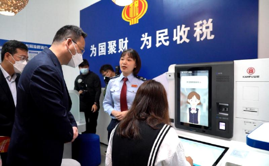 在龙华区党群服务中心税e站内，税务人员正在向企业纳税人介绍税e站服务功能