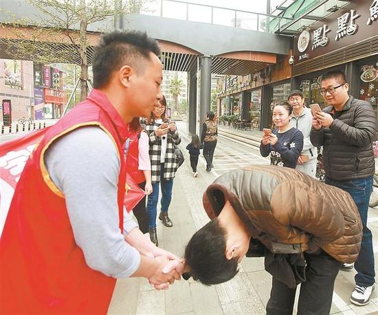 严小军向志愿者鞠躬致谢。