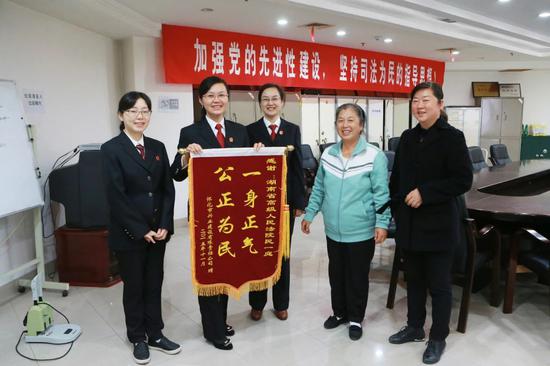 当事人给周春梅法官(左二)所在的庭审送锦旗