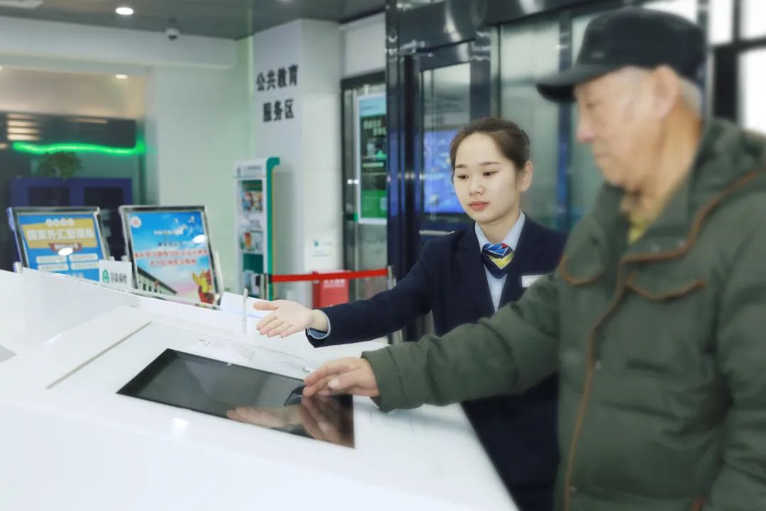邮储银行网点工作人员指导老年人使用智能机具