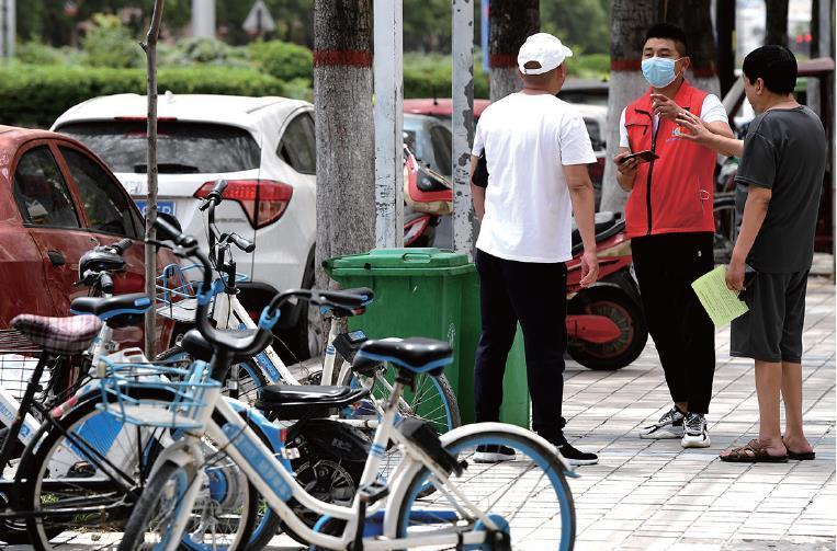 一名社区工作者(中)与居民交谈 李安 摄
