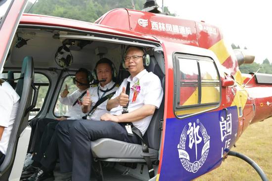 △首飞嘉宾：郎酒集团党委书记李明政（右）、德阳市人大常委会主任卢也（左）、西林凤腾通航董事长林孝波（中）