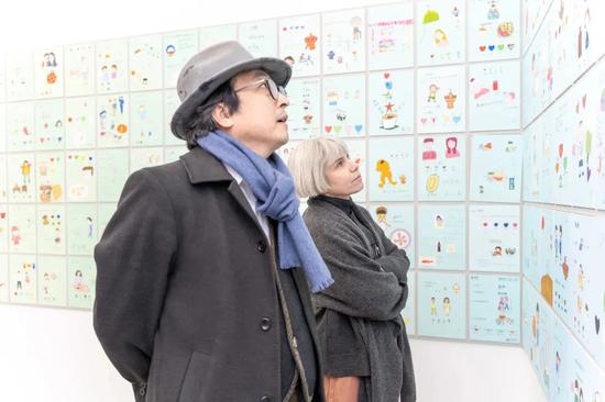 展览开幕当天,艺术家张伟夫妇正驻足观看医生画作