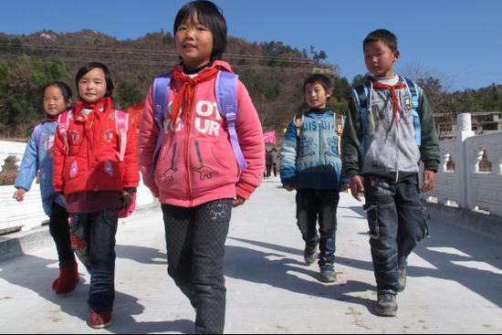 （图：安徽金寨金田村，苏宁援建的便民桥竣工后，孩子们开心的走在桥上。）