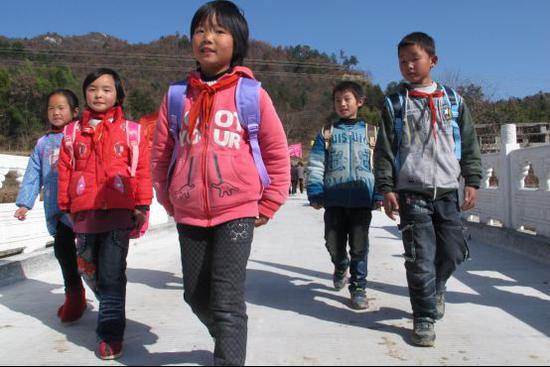 (图:安徽金寨金田村,苏宁援建的便民桥竣工后,孩子们开心的走在桥上。)