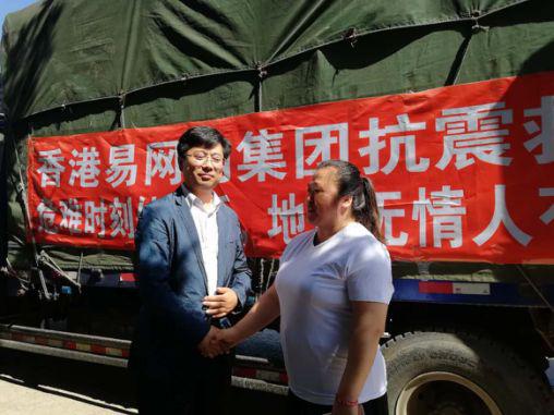 易网购辽宁分公司法人兼董事长邹女士（右）与救灾安置办张主任（左）握手